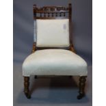 A Victorian walnut chair raised on turned legs and castors
