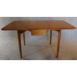 A Gordon Russell style golden oak drop flap dining table. H.75 W.145 D.85cm