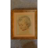 A glazed and framed pencil drawing and highlighted portrait of a young child, signed. 37x33cm
