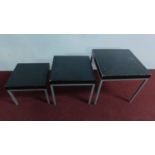 A nest of 3 modern stained oak tables on metal tubular frames. H.50 W.50 D.50