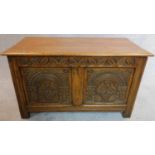 A Jacobean style carved oak coffer with hinged lid. H.52 W.92 D.49cm