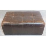 A large distressed buttoned brown leather footstool. H.40 W.100 D.60cm