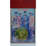 A framed poster of The Beatles, Sgt Peppers Lonely Hearts Club Band, inset with a vinyl picture disc