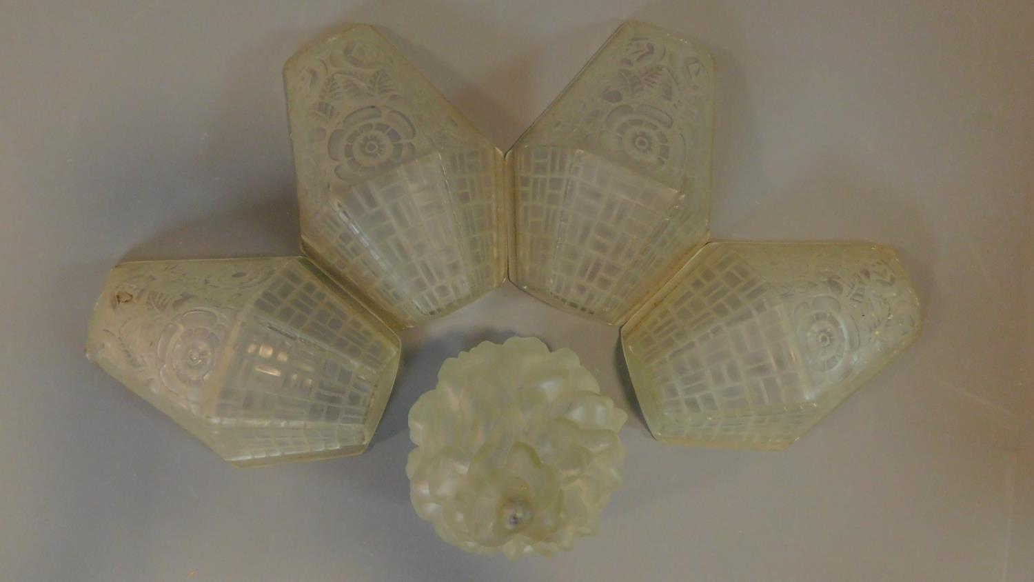 A set of four Art Deco frosted glass light shades and a similar torch style shade. H.25 W.18 D.9cm