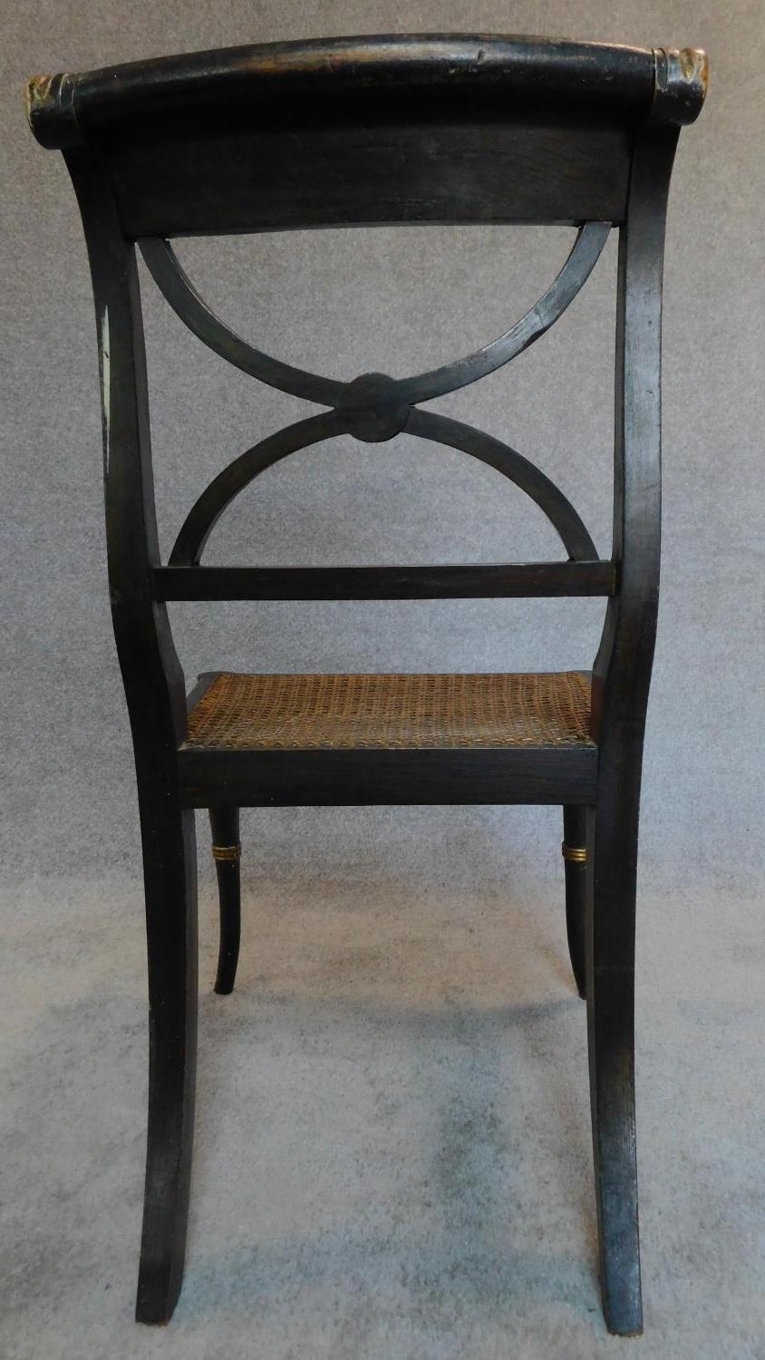 A pair of Regency ebonized and part gilt painted chairs with cane seats, the X-framed back rests - Image 4 of 6