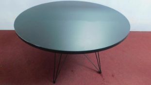 A contemporary designer circular table, lacquered top on hairpin supports. H.75 W.120cm
