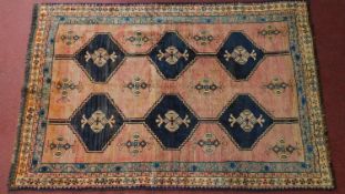 A southwest Persian Lori rug, repeating stylised geometric motifs on a madder ground guarded by a