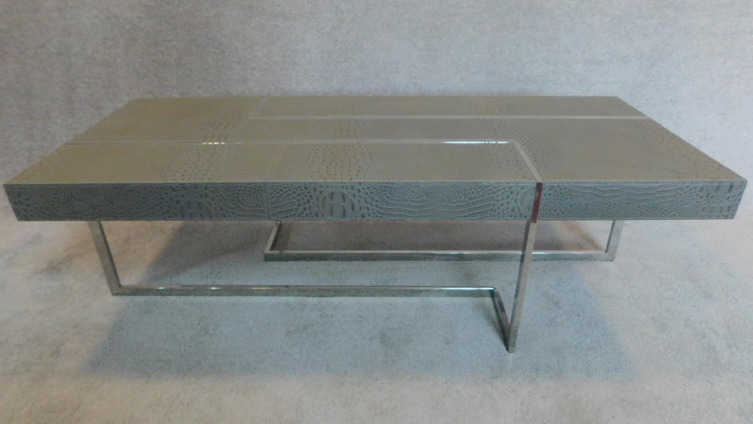 A Roche Bobois contemporary coffee table with faux grey crocodile skin cladding, raised on chrome