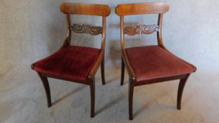 A pair of Regency mahogany and satinwood strung dining chairs on sabre supports. H.80 W.46 D.50cm (