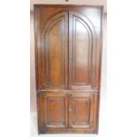 A large Georgian oak twin section cupboard fitted arched panel doors of demi lune cross section.