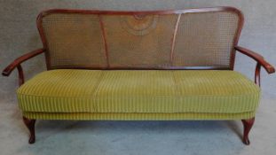 A mid 20th century bergere caned sofa, makers label to base. H.86 W.170 D.60cm