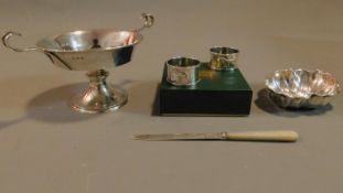 An English hallmarked silver tazza, a pair of napkin rings, a mother of pearl handled paper knife