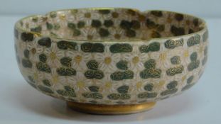An early 20th century Japanese satsuma bowl in pink, black and gilt with flowerheads and foliage,