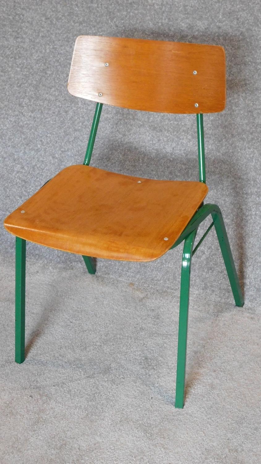 A set of eight mid 20th century metal framed stacking chairs with plywood seats and backs.