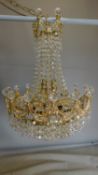 A gilt metal and crystal chandelier of basket form. All crystals present. 65x44cm.