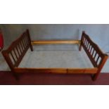 A country style stained pine bedstead to take a 4'6" mattress. 90x200x143cm