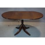 An inlaid mahogany drop leaf table, on turned pedestal support and lion paw feet and castors, 93 x