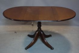 An inlaid mahogany drop leaf table, on turned pedestal support and lion paw feet and castors, 93 x