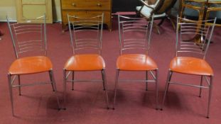 Four vintage 1960's French dining chairs, with orange vinyl seats on tapered legs