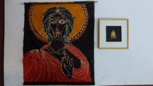 A framed and glazed carving of a deity and a religeous scroll. 72x62cm.