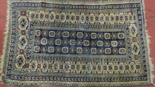 A Persian Turkoman Rug with repeating motifs, on a blue and cream ground with multi geometric