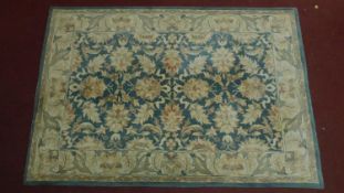 A large woollen floral design carpet. 245x168cm (wear to one edge)