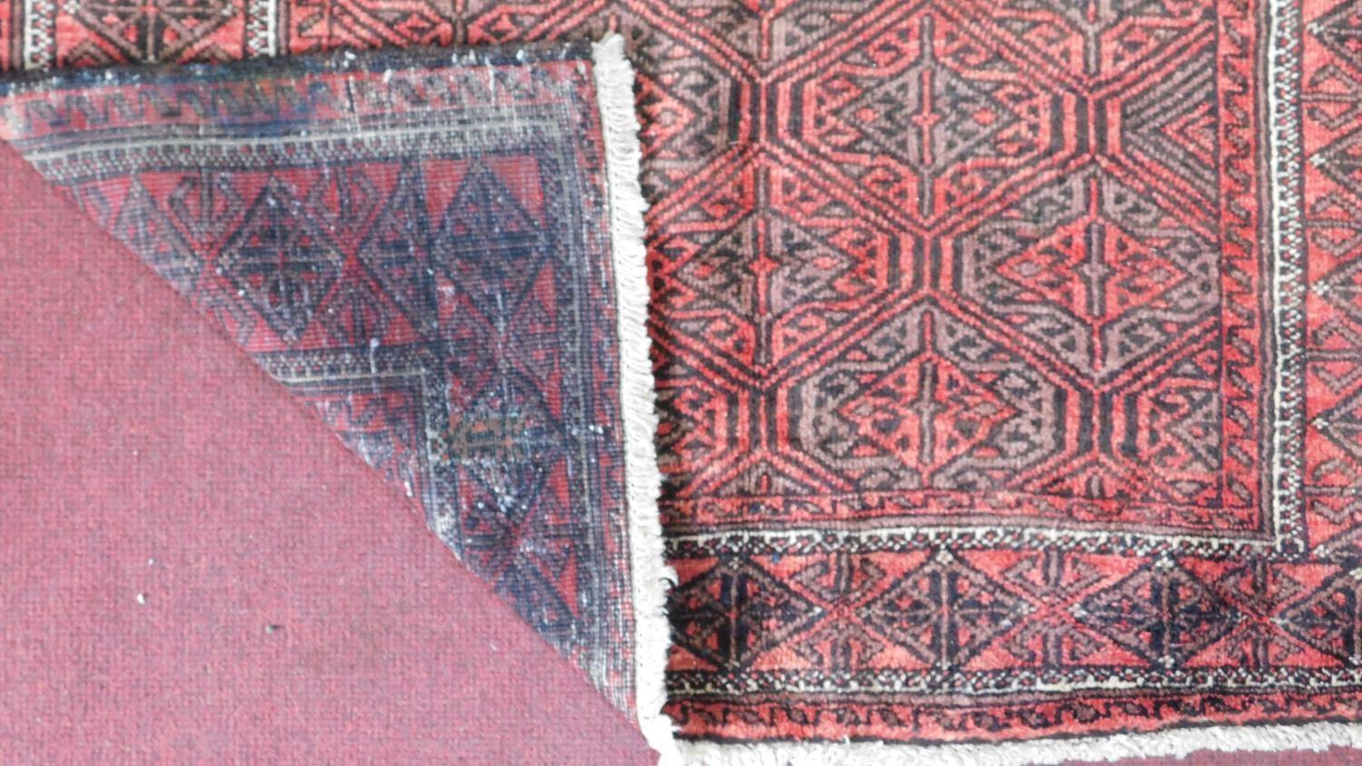A north east Persian Hatchlie carpet with repeating stylised geometric motifs on a rouge field - Image 3 of 3