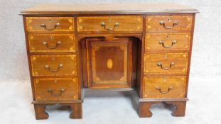 An Edwardian mahogany and satinwood inlaid kneehole desk fitted arrangement of nine drawers and a