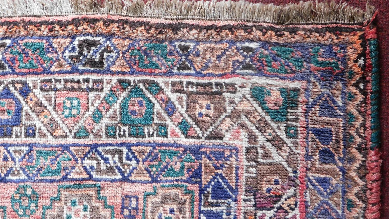 A Persian Qashqai rug with triple pole medallion and repeating geometric motifs on a terracotta - Image 2 of 4