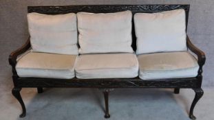 A 17th century linenfold carved oak settle with fitted modern squab cushions on cabriole supports.