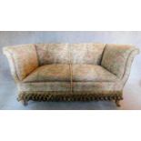 An Edwardian two seater sofa in floral tassled upholstery. 76x137x77cm