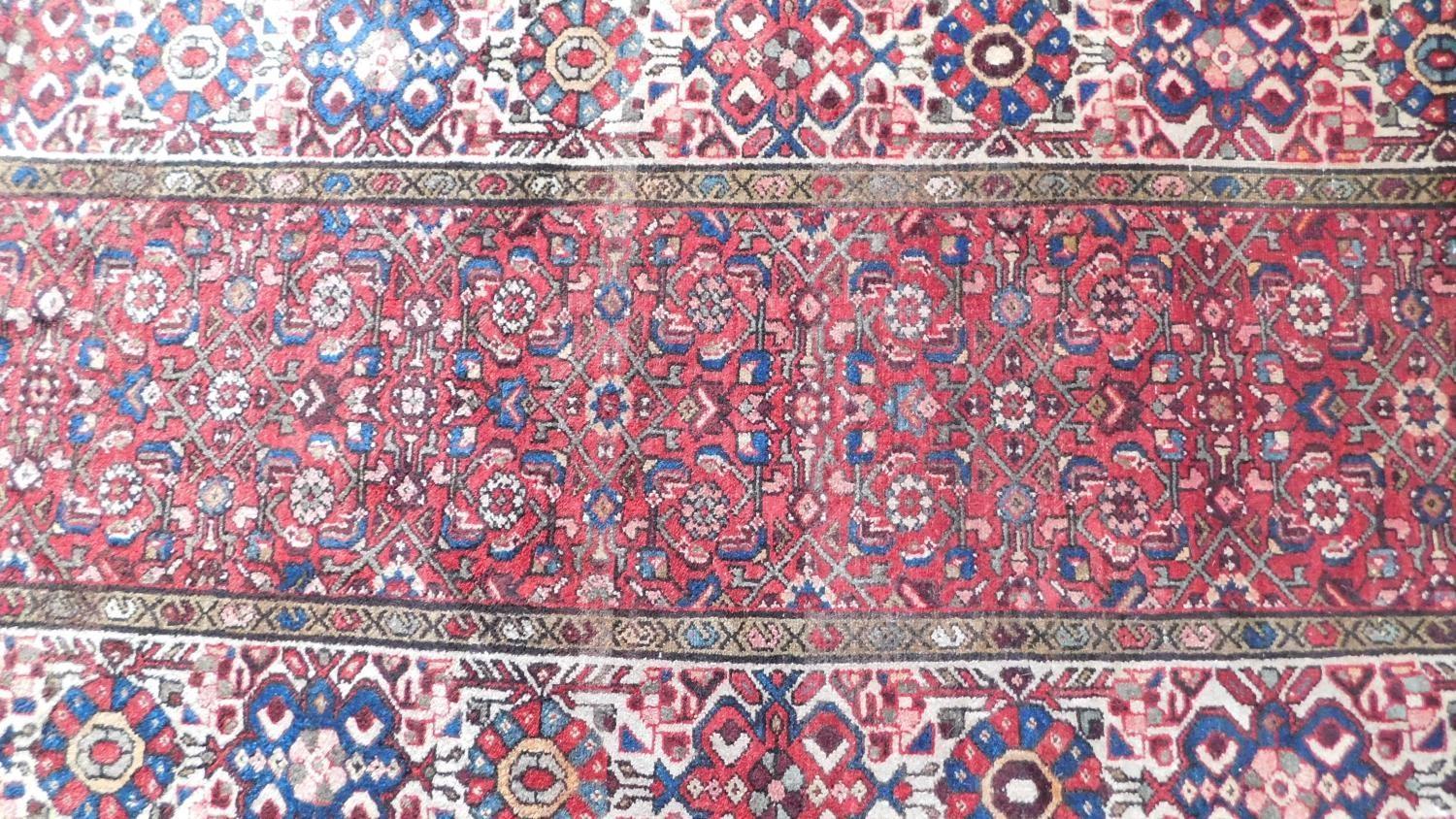 A Persian Heriz style runner, repeating stylised gul motifs on a terracotta field, within - Image 4 of 4