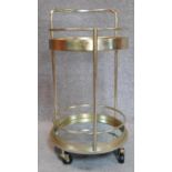A gilt metal Art Deco style drinks trolley with mirrored shelves on casters. H.77cm