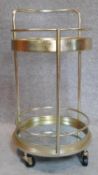 A gilt metal Art Deco style drinks trolley with mirrored shelves on casters. H.77cm