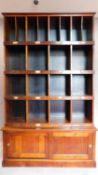 A mahogany two section estate cupboard fitted pigeon holes and stationery sections, makers label