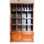 A mahogany two section estate cupboard fitted pigeon holes and stationery sections, makers label