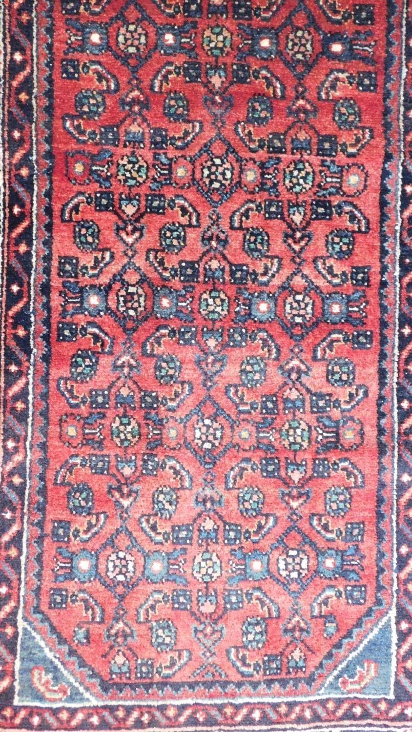 A Persian Malayer runner, repeating heratie motifs on a terracotta field within stylised multifloral - Image 2 of 4