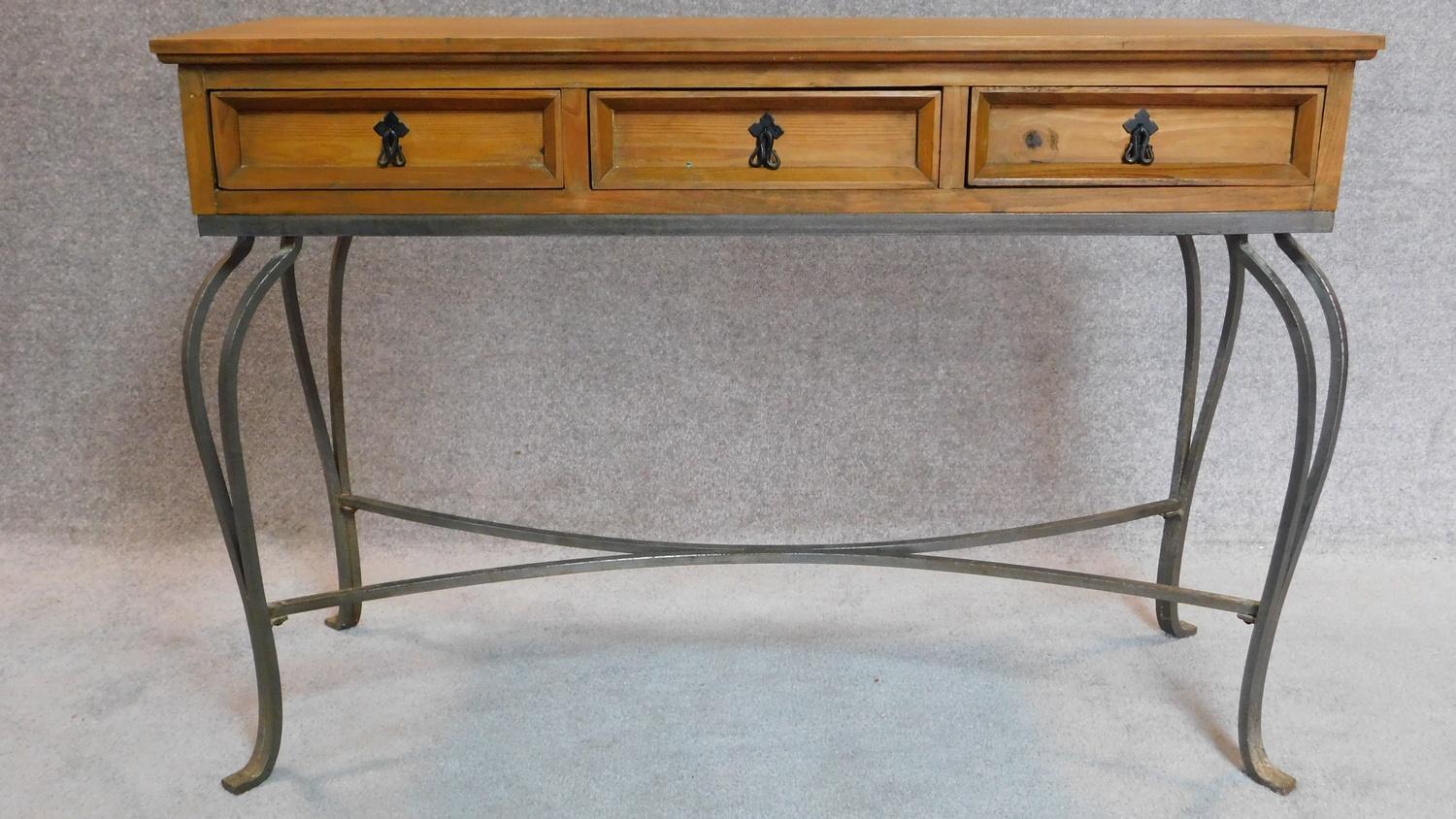 20th Century pitch pine console table with three drawers on cabriole wrought iron legs.