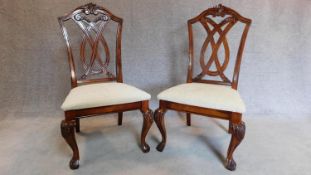 A pair of carved American Colonial style dining chairs, upholstered in cream stuffover seats. H.