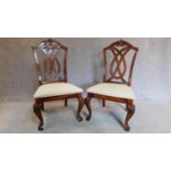 A pair of carved American Colonial style dining chairs, upholstered in cream stuffover seats. H.