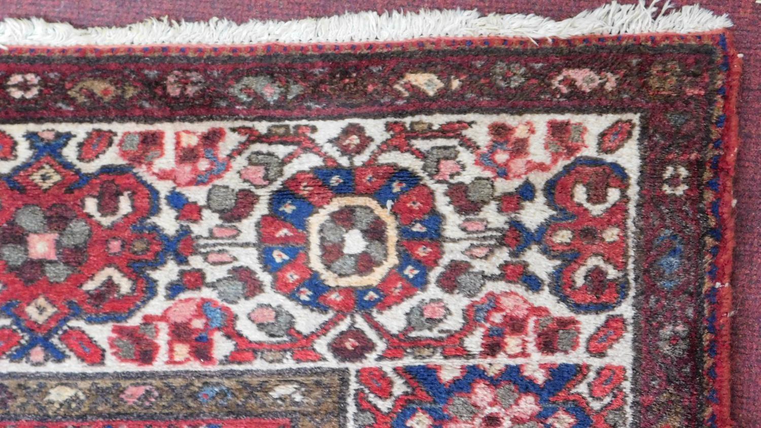 A Persian Heriz style runner, repeating stylised gul motifs on a terracotta field, within - Image 2 of 4