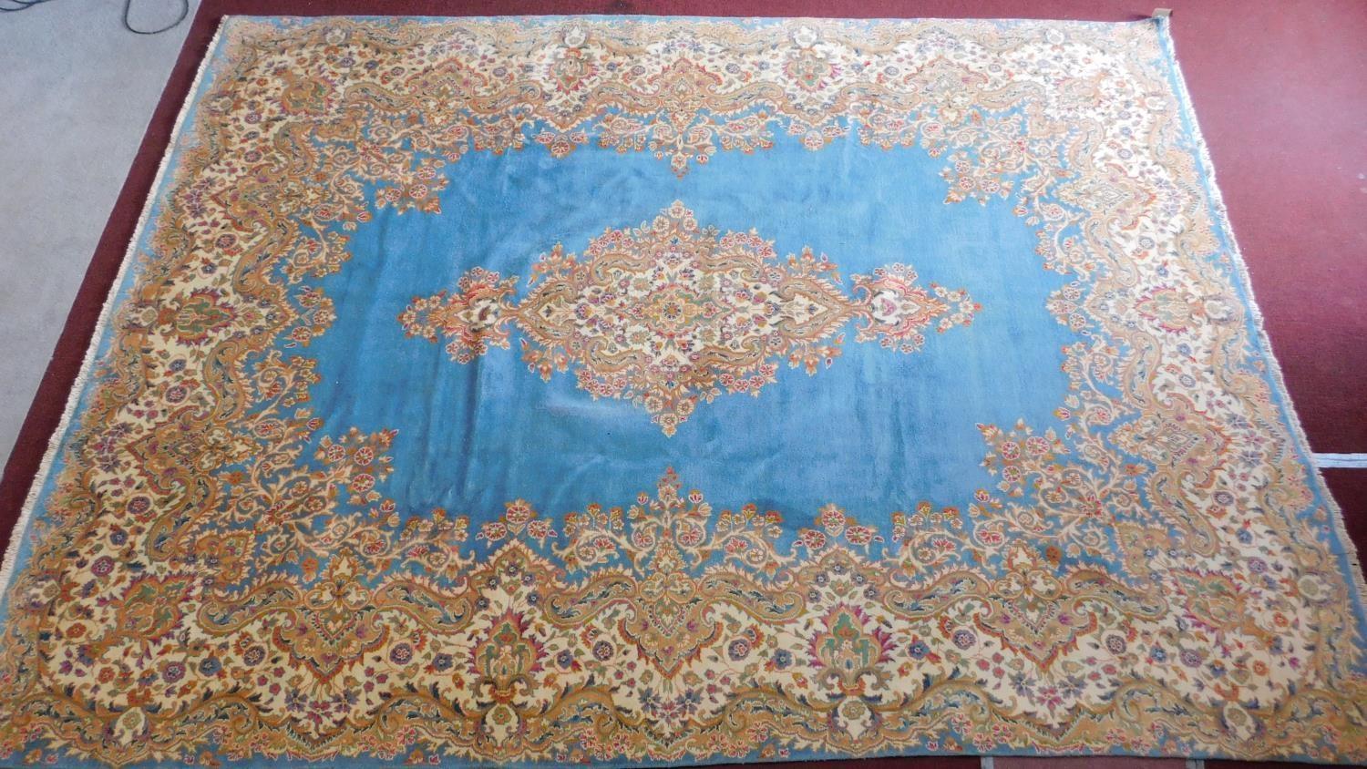 A Royal Kirman carpet with central double pendant medallion with repeating petal motifs on a sky