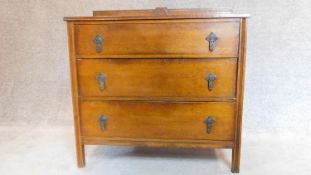 A mid 20th century oak three drawer chest with brass handles and carved back. H.89 W.91 D.46cm