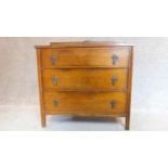A mid 20th century oak three drawer chest with brass handles and carved back. H.89 W.91 D.46cm