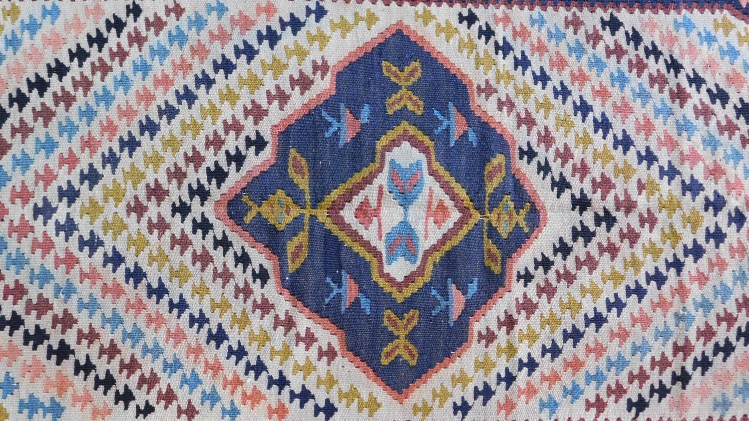 A Qashgai Kelim rug with central pole medallion and repeating geometric motifs on an ivory field. - Image 2 of 4