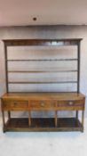 An 18th century country oak dresser, the upper plate rack section above base with frieze drawers