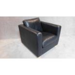 A contemporay black leather armchair on block feet. 70x82x90cm