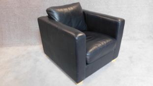 A contemporay black leather armchair on block feet. 70x82x90cm