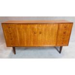 A Gordon Russell sideboard fitted drawers and cupboards on splayed supports, makers label to back.