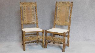 A pair of antique oak side chairs, allover carving, caned back and seats. H.110cm